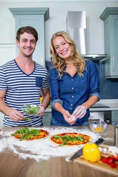 Smiling couple preparing pizza