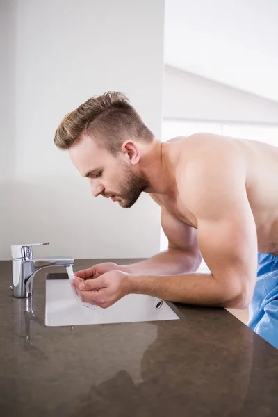 Man drinking water from sink