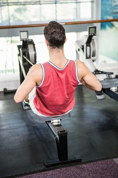 Muscular man on rowing machine