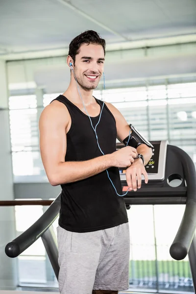 Smiling man on treadmill using smart watch