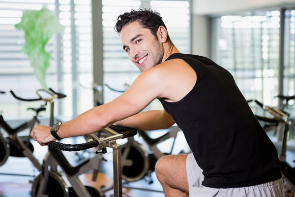 Smiling man using exercise bike