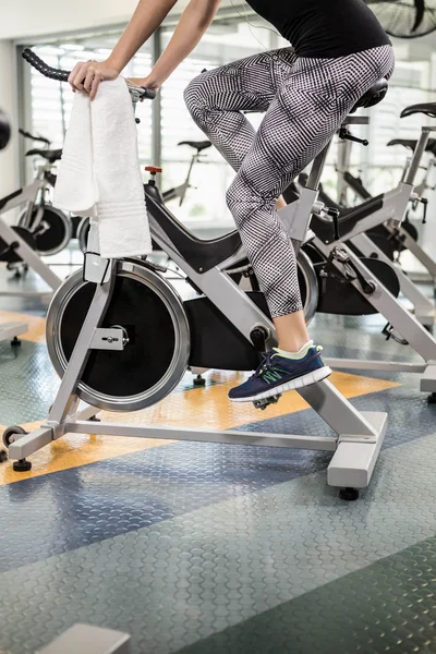 Lower section of fit woman on exercise bike