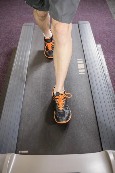 Lower section of man running on treadmill