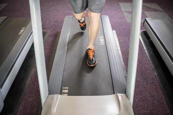 Lower section of man running on treadmill