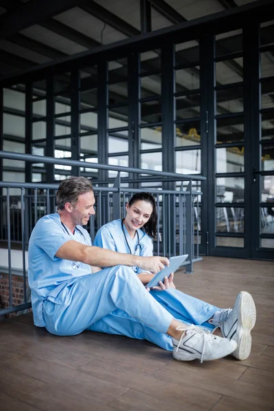 Two nurses sitting on floor and talking