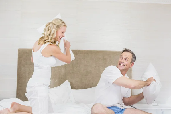 Cute couple playing pillow fight