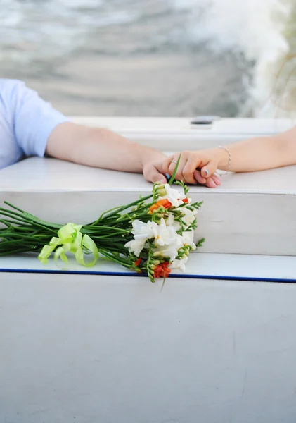 Hands and bouquet on the boat