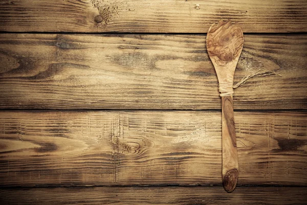Wooden spoon on old wooden burned table or board for background.