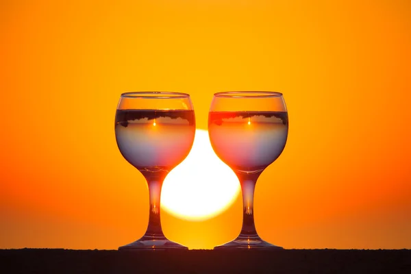 Glasses of white vine with reflections of houses and view to bea