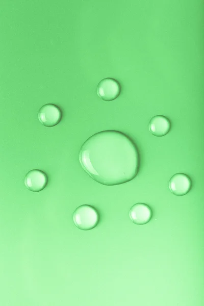 Drops of water on a color background. Green. Toned
