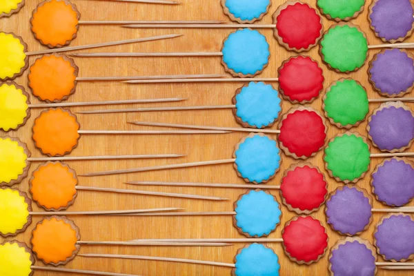 Gingerbread cookies with colored mastic on sticks on the old woo