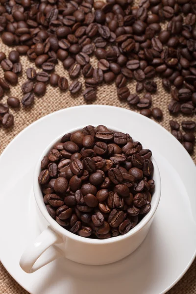Coffee beans and coffee in cup on burlap. Selective focus
