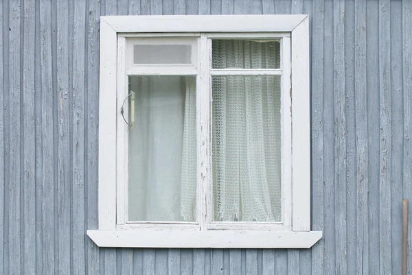 Window on the old wooden houses painted wall. Selective focus