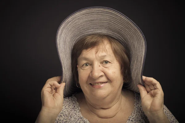 Portrait of elderly woman with a hat. Smile. Toned