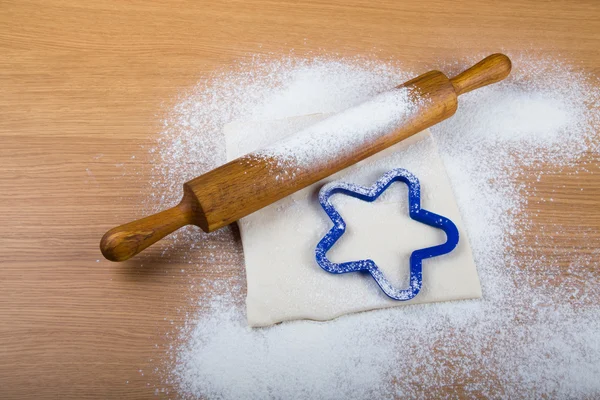 Set for home baking on a light wooden table with flour. Rolling