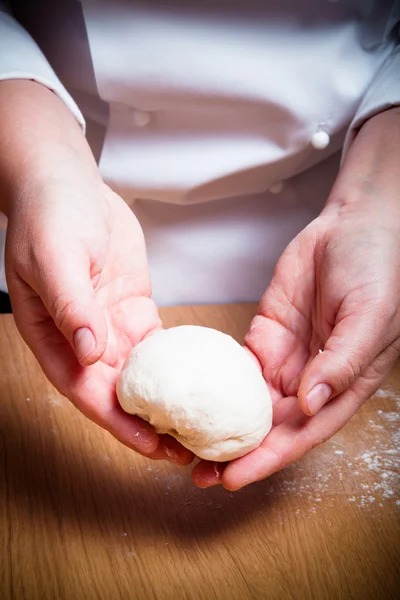 Female hands cut up dough. Selective focus. Toned