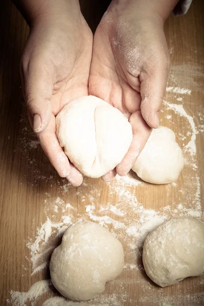 Female hands cut up dough. Selective focus. Toned