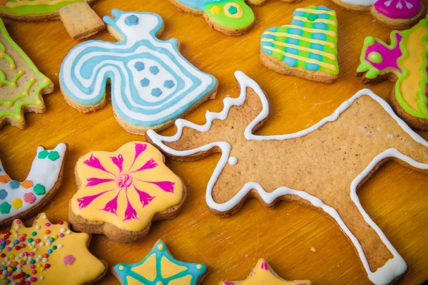 Gingerbread homemade cookies with icing colored drawings on wood