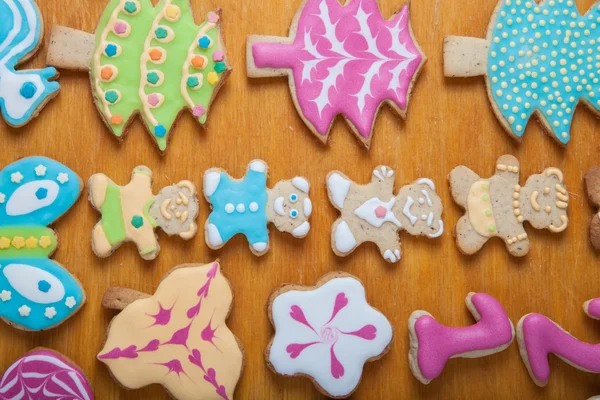 Gingerbread homemade cookies with icing colored drawings on wood