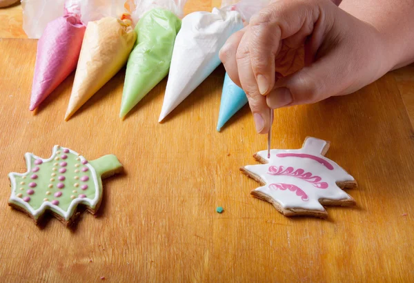 Woman\'s hands in process of drawing on new year gingerbread cook