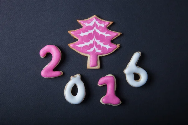 Gingerbread homemade cookies with icing on a black table or boar