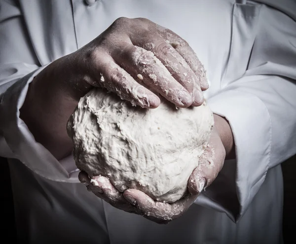 Raw dough in a chef hands. Toned