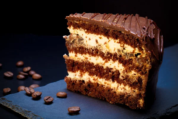 Chocolate cake on slate plate on black background. Selective foc