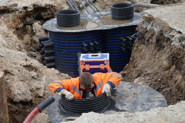 MOSCOW, RUSSIA - MAY 15, 2016: Working down in the maintenance shaft. Reconstruction of the roadway within the city beautification program My Street in Moscow.