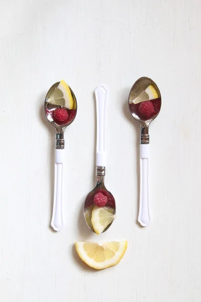Health or detox diet food idea, spoon with lemon and raspberrieson.