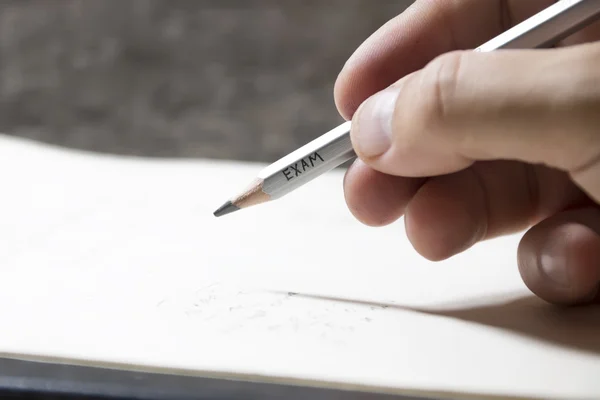 Student writing a test, an inscription on pencil \