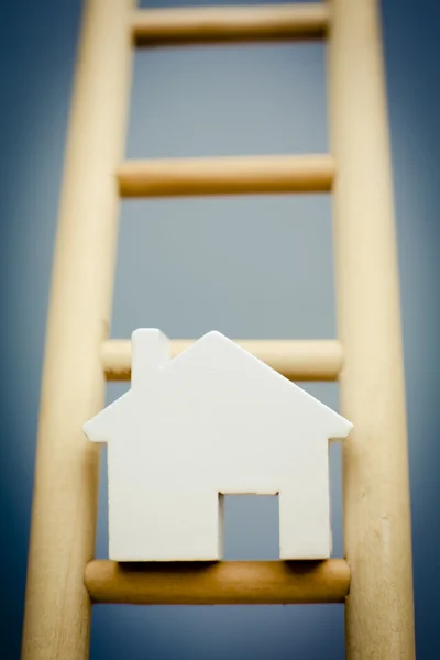 Model House On Rung Of Wooden Property Ladder
