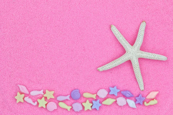 Star fish, known as sea stars, and marine life beads on pink fine sand