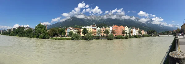 Panoramic view of colorful buildings and mountains along Inn river