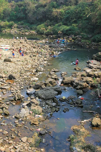 Local people bathing and washing clothes along the river in Pokhara city, Nepal.