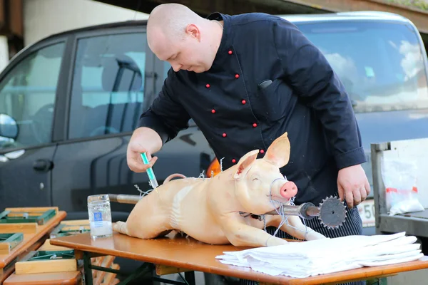 A man using meat injector injecting essential into a pig