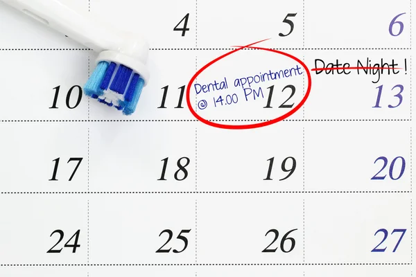 Dental appointment marked on a white calendar with date night being cancelled