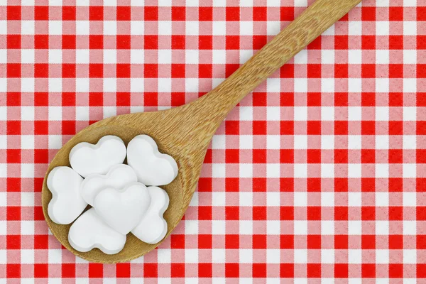 Heart shaped candy pills on red gingham checkered background