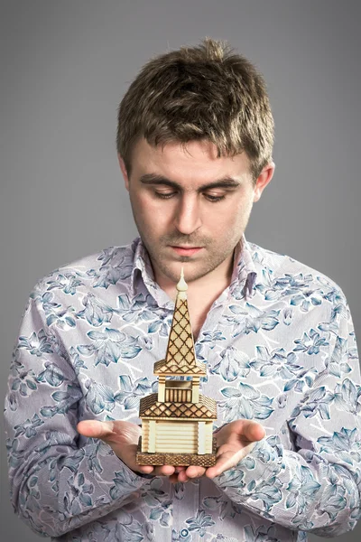 Model of the house in the hands of men