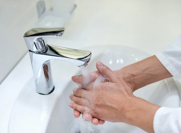 Washing hand and turn off faucet out door,doctor man