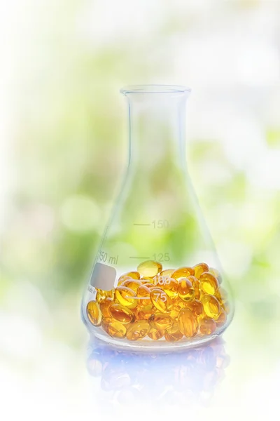 Medical pills in the Erlenmeyer flask on nature background