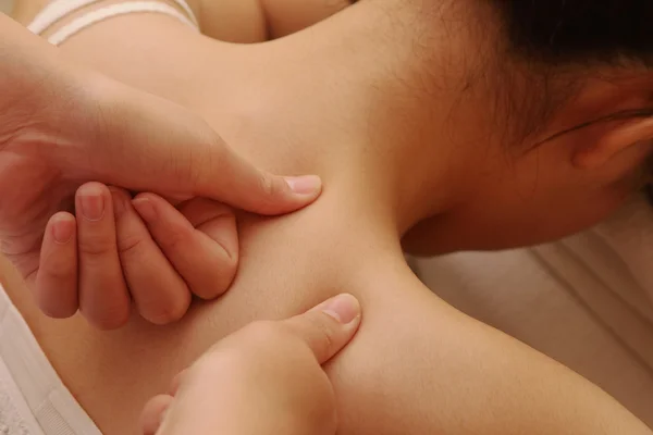 Deep massage on a woman\'s shoulder and neck
