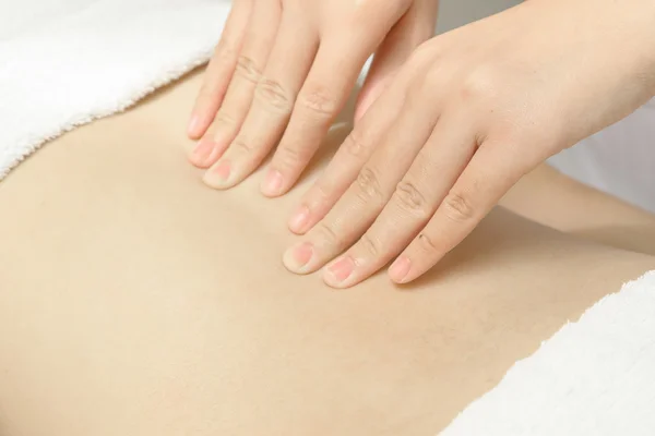 Masseur applying massage techniques to relax back muscles in