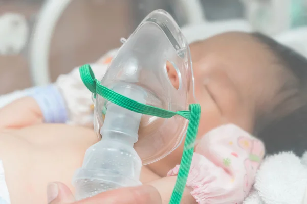 Baby patient in oxygen mask ,Making inhalation with oxygen mask