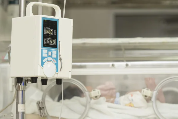 Infusion pump feeding IV drip into baby\'s patients
