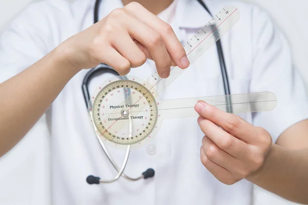 Physiotherapist holding a goniometer for measuring range of mo