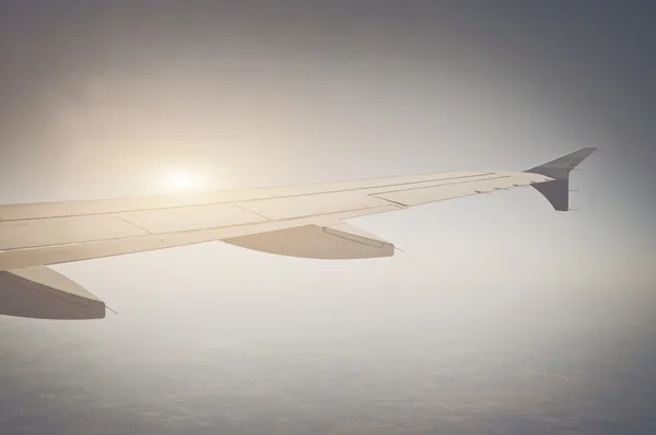 Wing of an airplane flying above the clouds