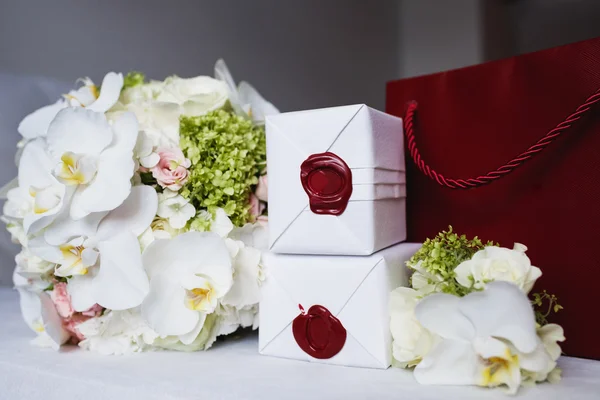 Wedding rings in a box near a wedding bouquet