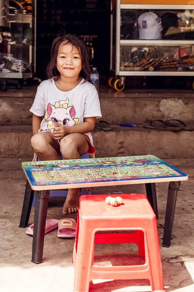 SIEMREAP, CAMBODIA - JAN 25, 2016: The cambodian girl sit near the road