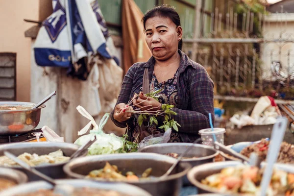 SIEMREAP, CAMBODIA - JAN 25, 2016: the woman sells food on the street