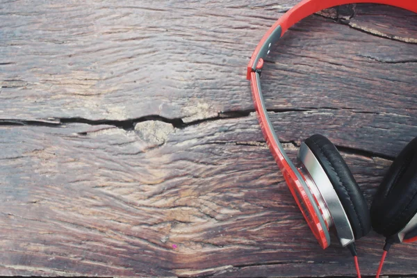 Red headphones on wood background